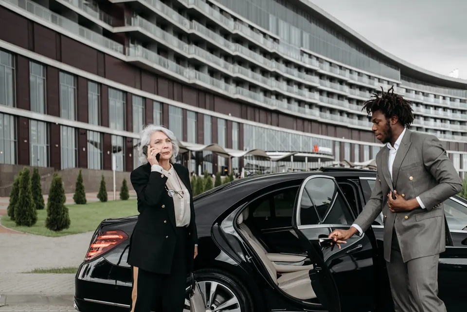 A chauffeur opening a car door for a passenger